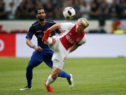 Kasper Dolberg (r.) probeert tijdens zijn debuut voor Ajax in de Champions League-voorronde op een stijlvolle manier af te rekenen met PAOK-verdediger Ángel Crespo (l.). (26-07-2016)