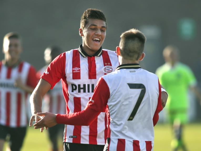 Joël Piroe (m.) viert een doelpunt voor de B1 van PSV. Het jeugdelftal van de Eindhovenaren speelt op sportpark De Toekomst tegen de leeftijdsgenoten van Ajax. (31-10-2015)