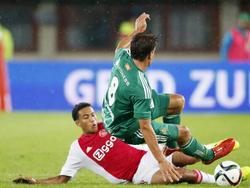 Jaïro Riedewald (l.) moet vrezen voor zijn ledematen, als Stefan Schwab met twee gestrekte benen inkomen tijdens de Europese wedstrijd Rapid Wien - Ajax. (29-07-2015)