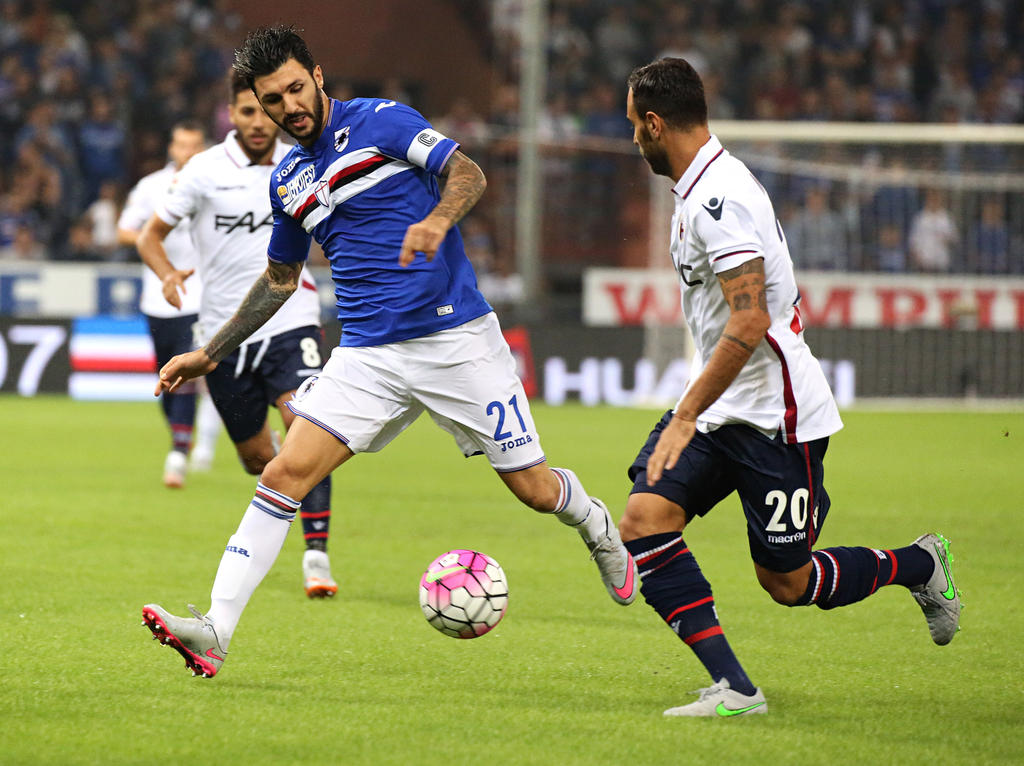 Roberto Soriano (l.) speelt de bal namens Sampdoria langs Domenico Maietta van Bologna. (14-9-2015)