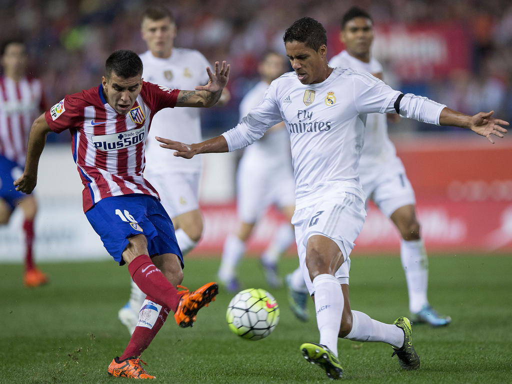Ángel Correa probeert met zijn uitgestoken been een pass van Raphaël Varane te voorkomen tijdens de derby tussen Atlético Madrid en Real Madrid. (04-10-2015)