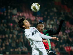 Ryo Miyaichi (l.) en Anthony Limbombe vechten een duel uit in de lucht tijdens NEC - Jong FC Twente. (28-11-2014)