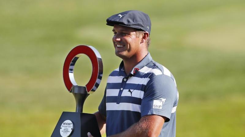 Bryson DeChambeau hält die Trophäe des Golfturniers Rocket Mortgage Classic in den Händen Bryson DeChambeau hält die Trophäe des Golfturniers Rocket Mortgage Classic in den Händen