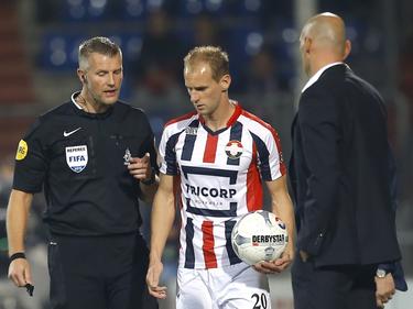 Richard Liesveld (l.) spreekt Frank van der Struijk (m.) toe terwijl Willem II-trainer Jurgen Streppel toekijkt. (03-10-2015)