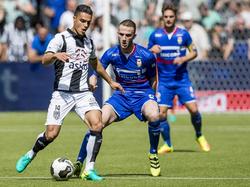 Joey Pelupessy (l.) wordt tijdens de wedstrijd Heracles Almelo - Willem II scherp in de gaten gehouden door Branco van den Boomen (m.). (14-08-2016)