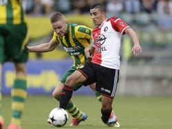Bilal Başaçikoğlu (r.) duelleert met Aaron Meijers (l.) tijdens ADO Den Haag - Feyenoord. (10-8-2014)