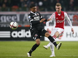Dabney dos Santos (l.) probeert een schot van Daley Sinkgraven (r.) te blokken tijdens Ajax - AZ Alkmaar. (05-02-2015)