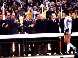 Argentiniens Kapitän Daniel Passarella nimmt den Siegerpokal von Diktator Jorge Rafael Videla (l.) entgegen
