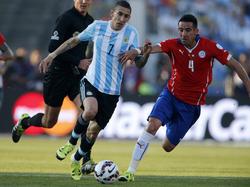 Ángel Di María (l.) probeert Maurcio Isla (r.) te passeren tijdens de finale van de Copa América tussen Chili en Argentinië. (04-07-2015)