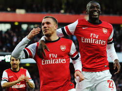 Lukas Podolski (M.) hat soeben das vorentscheidende Tor im FA-Cup zwischen Arsenal und Liverpool erzielt und lässt sich von Teamkollege Yaya Sanogo (r.) feiern.