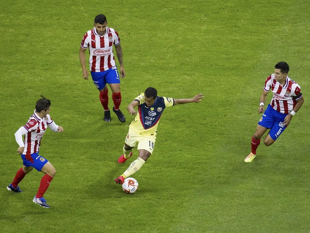 Giovani Dos Santos se intenta zafar de tres rivales.