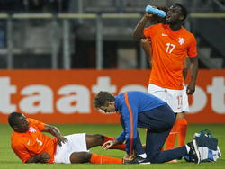 Elvis Manu (r.) neemt een slokje drinken, terwijl Jetro Willems (l.) een blessurebehandeling ondergaat tijdens de EK-kwalificatiewedstrijd Jong Oranje - Jong Portugal. (09-10-2014)
