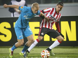 Igor Smolnikov (l.) van Zenit St. Petersburg vecht met PSV'er Adam Maher om de bal in de zestiende finale van de Europa League. (26-02-2015)