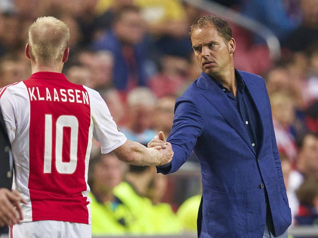 Frank de Boer (r.) kijkt bezorgd naar Davy Klaassen als de middenvelder het veld geblesseerd verlaat tegen Heracles Almelo. (13-09-2014)