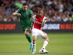 Ajax-middenvelder Hakim Ziyech (r.) verstuurt onder druk van Danny Holla (l.) een pass tijdens de wedstrijd tegen PEC Zwolle.