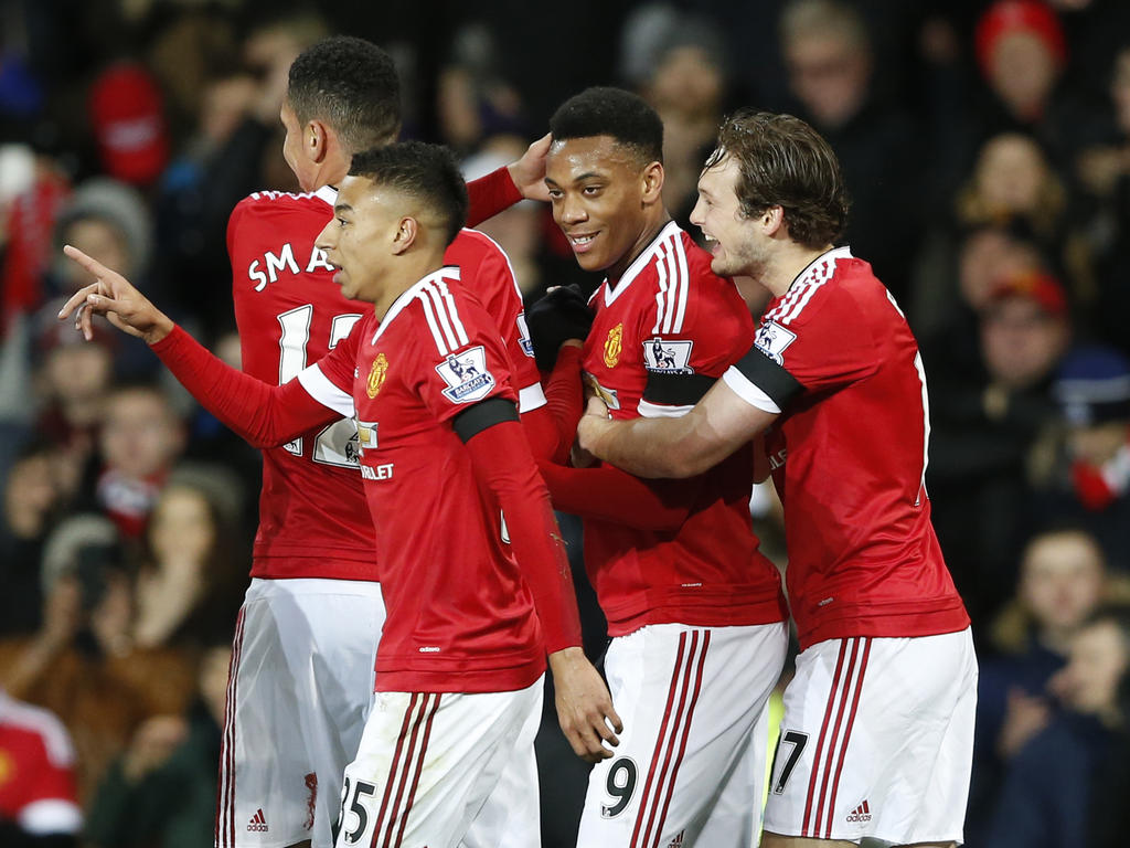 Anthony Martial scoort namens Manchester United de 2-0 tegen Stoke City en wordt geknuffeld door Daley Blind (r.). Ook Jesse Lingard en Chris Smalling (r.) vieren het feestje mee. (02-02-2016)