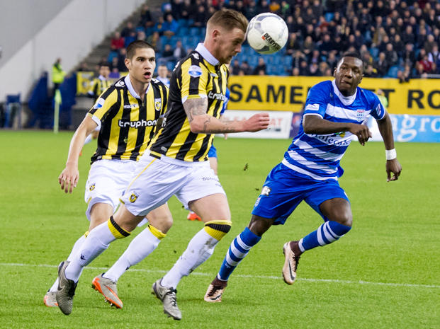 Voormalig PEC Zwolle-verdediger Maikel van der Werff (m.), hier in balbezit voor Vitesse, neemt de bal kundig mee met het hoofd. PEC Zwolle-aanvaller Sheraldo Becker probeert bij te houden.