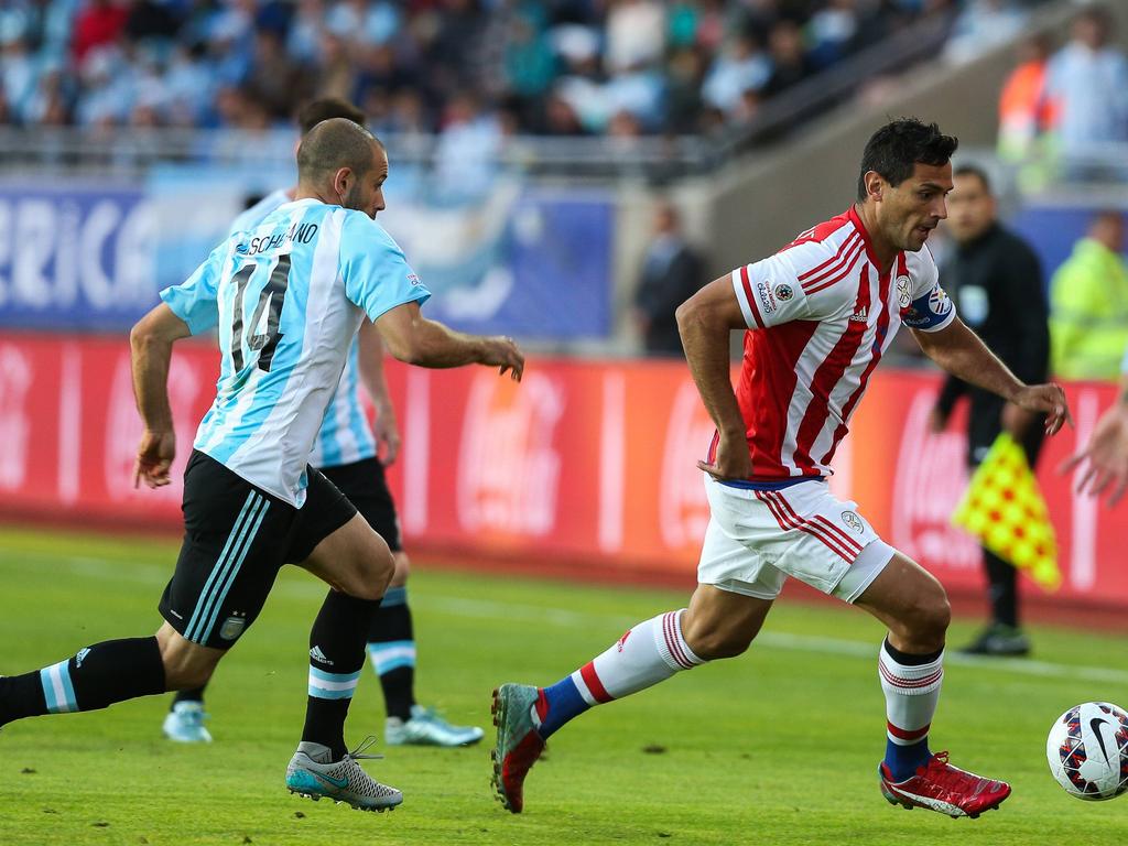 Santa Cruz (dcha.) se marcha de Mascherano en el duelo Argentina-Paraguay. (Foto: Imago)