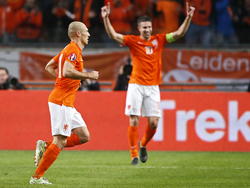 Arjen Robben (l.) blijft kalm nadat hij Nederland op een 2-0 voorsprong zet tegen Letland. Robin van Persie juicht op de achtergrond wel. (16-11-2014)