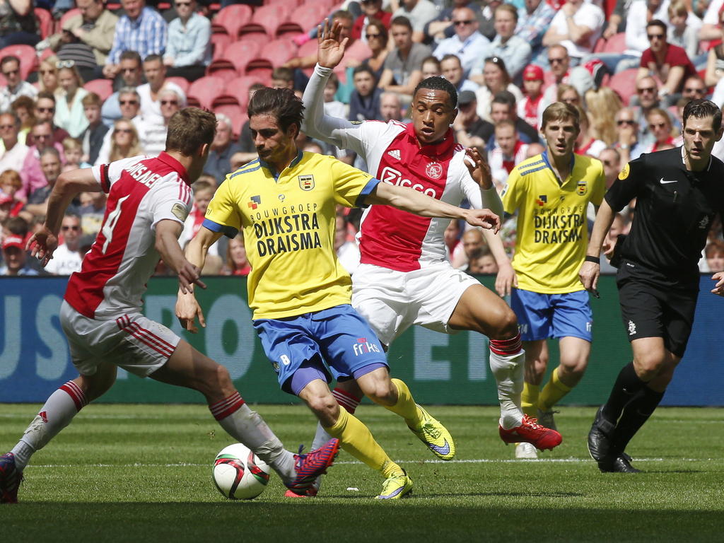 Daniël de Ridder (m.) probeert Niklas Moisander (l.) en Kenny Tete (r.) te omzeilen tijdens het competitieduel Ajax - SC Cambuur. (10-05-2015)