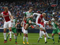Ben Rienstra (m.) van PEC Zwolle klopt Ajacied Nicolai Boilesen (r.) in de lucht en kopt maar net naast. (05-10-2014)