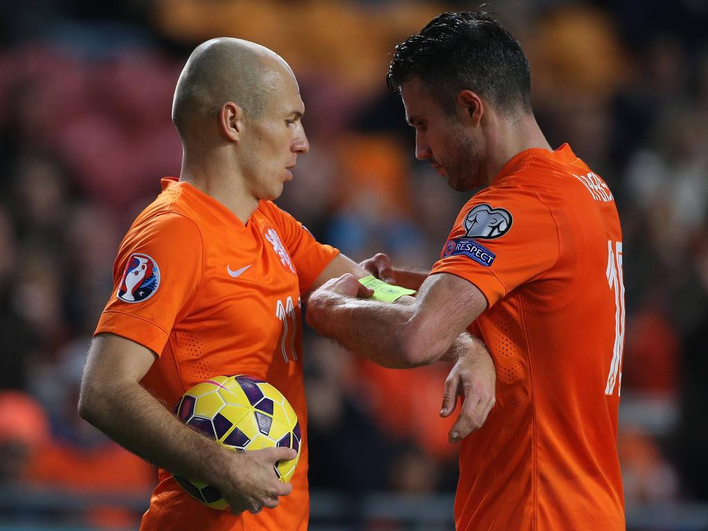 Robin van Persie (r.) schuift de aanvoerdersband om de arm van Arjen Robben (l.) tijdens het EK-kwalificatieduel Nederland - Letland. Voetbal.com Foto van de Week. (16-11-2014)