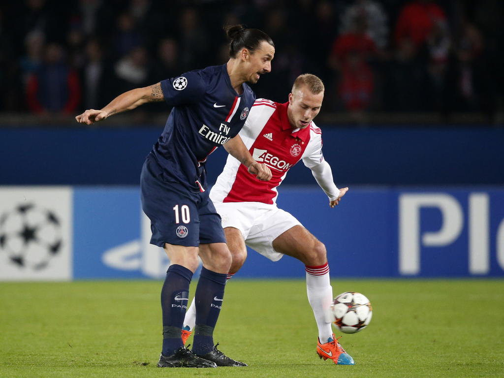 Mike van der Hoorn (r.) is niet bij machte om Zlatan Ibrahimovic (l.) van de bal te krijgen in de Champions League-wedstrijd tussen Paris Saint-Germain en Ajax. (25-11-2014)