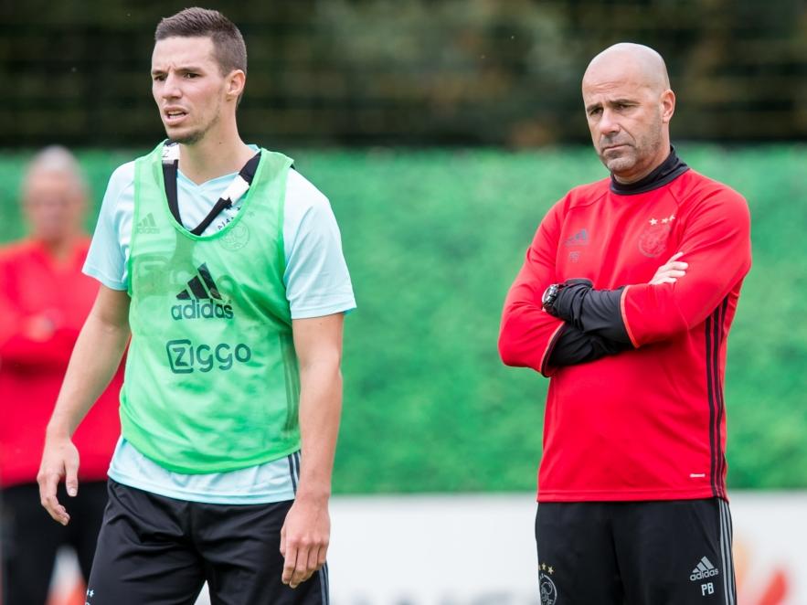 Nieuwbakken Ajax-trainer Peter Bosz (r.) kijkt van een afstand toe hoe onder anderen Nick Viergever (l.) het doet op de eerste training. (29-06-2016)