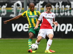 Tommy Oar (r.) van FC Utrecht verlegt het spel met ADO Den Haag-speler Mitchell Schet in de rug. (14-09-2014)