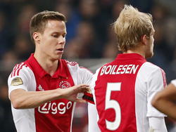 Niklas Moisander (l.) van Ajax moet eraf vanwege een rode kaart tegen AZ Alkmaar en geeft zijn aanvoerdersband aan ploeggenoot Nicolai Boilesen. (05-02-2015)