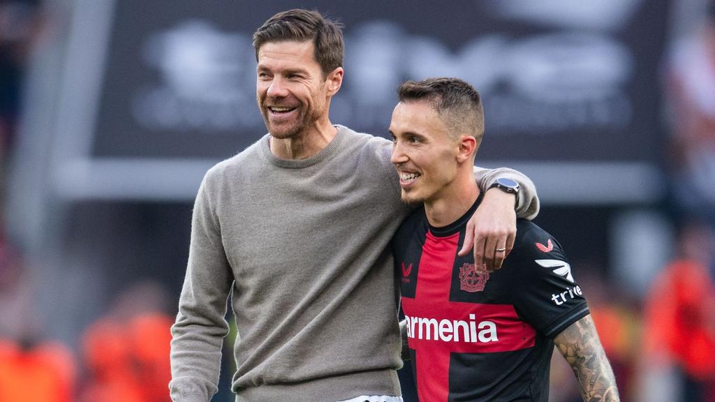 Leverkusens Trainer Xabi Alonso (l) und Alejandro Grimaldo liegen sich nach der Partie in den Armen. Leverkusens Trainer Xabi Alonso (l) und Alejandro Grimaldo liegen sich nach der Partie in den Armen.