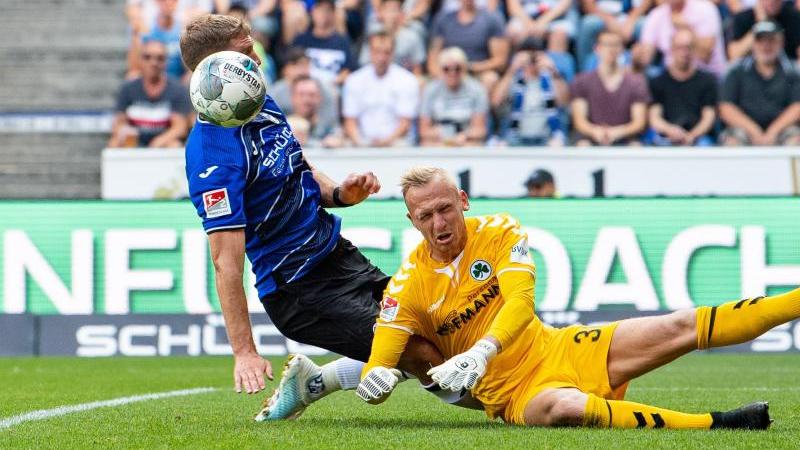 Fürth-Keeper Sascha Burchert versucht gegen Bielefelds Fabian Klos zu klären. Foto: Guido Kirchner