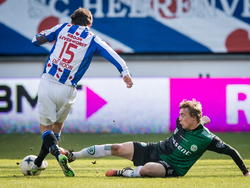 Simon Tibbling (r.) gaat naar de grond in een uiterste poging om Marten de Roon de weg te versperren tijdens sc Heerenveen - FC Groningen. (22-02-2015)