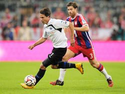 Bayern Münchens Xabi Alonso (r.) jagt Jens Wemmer vom SC Paderborn