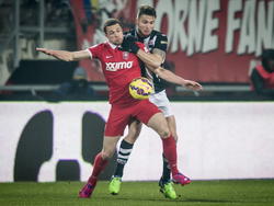 FC Twente-spits Luc Castaignos houdt Heracles Almelo-verdediger Bart Schenkeveld van zich af (23-01-2015).