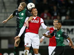 Michael de Leeuw (l.) en Nemanja Gudelj vechten een pittig duel in de lucht uit tijdens AZ - FC Groningen. (25-10-2014)