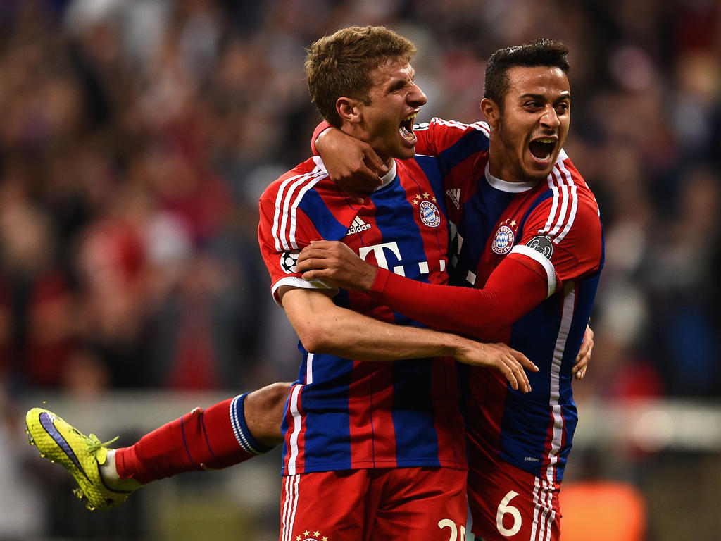 Bayern München-spelers Thomas Müller (l.) en Thiago (r.) kunnen wederom een feestje vieren na een doelpunt van de Duitsers tegen FC Porto. (21-04-2015)