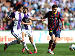 Stefan Mitrovič (l.) probeert namens Real Valladolid Lionel Messi (r.) af te stoppen.