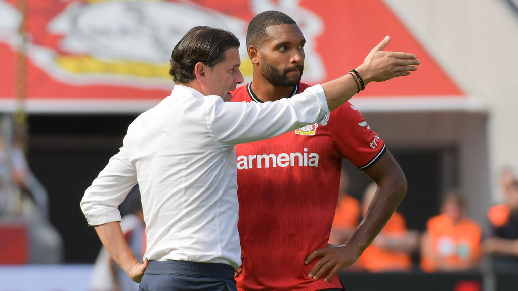 Leverkusens Trainer Gerardo Seoane (l.) spricht mit Jonathan Tah