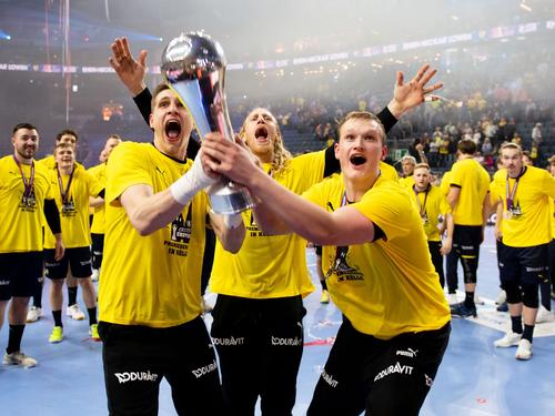 Joel Birlehm, Mikael Appelgren und David Späth von den Rhein-Neckar Löwen feiern mit dem Pokal