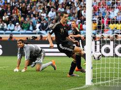 Argentiniens Sergio Romero (l.) muss 2010 im Spiel gegen Deutschland hinter sich greifen