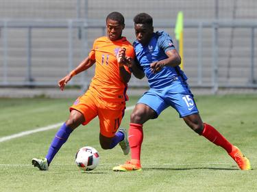 Kenneth Paal (l.) in duel met de Fransman Faitout Maouassa (r.) tijdens het EK U19 in Duitsland. (18-07-2016)