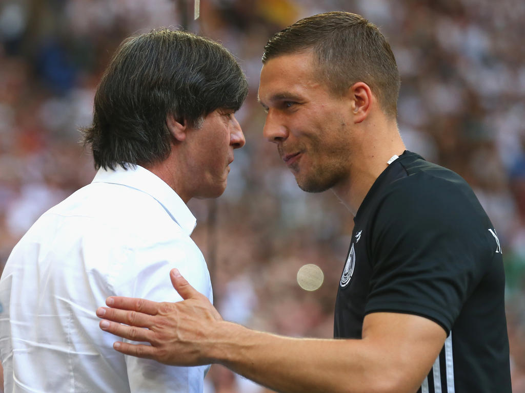 Lukas Podolski (r.) beim Handschlag mit Bundestrainer Joachim Löw
