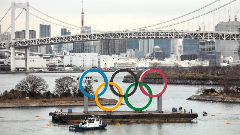 Übergroße olympischen Ringe werden auf einem Ponton in den Hafen von Tokio geschleppt Übergroße olympischen Ringe werden auf einem Ponton in den Hafen von Tokio geschleppt