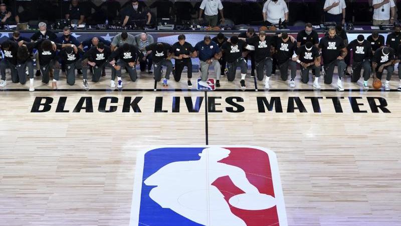 Alle Spieler der New Orleans Pelicans und von Utah Jazz knien vor einem "Black Lives Matter"-Schriftzug Alle Spieler der New Orleans Pelicans und von Utah Jazz knien vor einem "Black Lives Matter"-Schriftzug