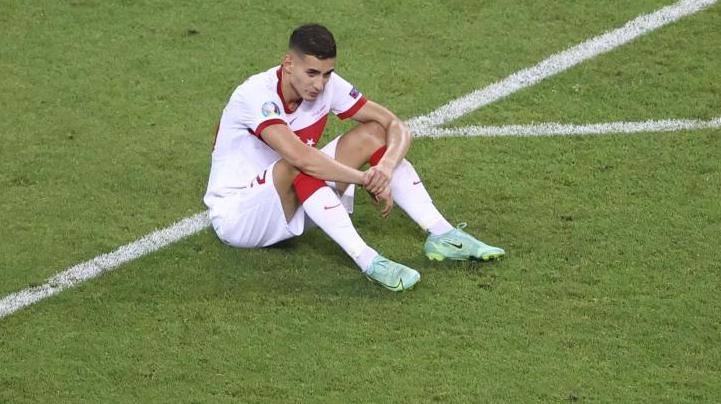 Der türkische Nationalspieler Mert Müldür sitzt nach dem EM-Aus auf dem Rasen