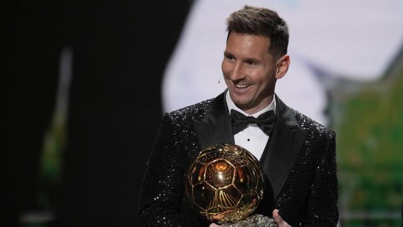 Lionel Messi von Paris Saint-Germain mit seiner Ballon d'Or-Trophäe 2021. Der Fußballer erhält den Goldenen Ball bereits zum siebten Mal in seiner Karriere. Foto: Christophe Ena/AP/dpa