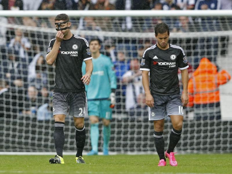Gary Cahill (l.), Thibaut Courtois (m.) en Eden Hazard (r.) nemen hun posities weer in na de 2-3 van West Bromwich Albion. Chelsea, dat met tien man staat, moet de voorsprong nog een halfuur verdedigen. (23-08-2015)