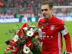 Philipp Lahm krijgt na afloop van het bekerduel Bayern München - VfL Wolfsburg de bloemen. (07-02-2017)