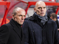 Voorafgaand aan het duel tussen FC Twente en Willem II overleggen Alfred Schreuder (l.) en Jurgen Streppel (r.) met elkaar, zonder uit het oog te verliezen wat er op het veld gebeurt. (21-12-2014)